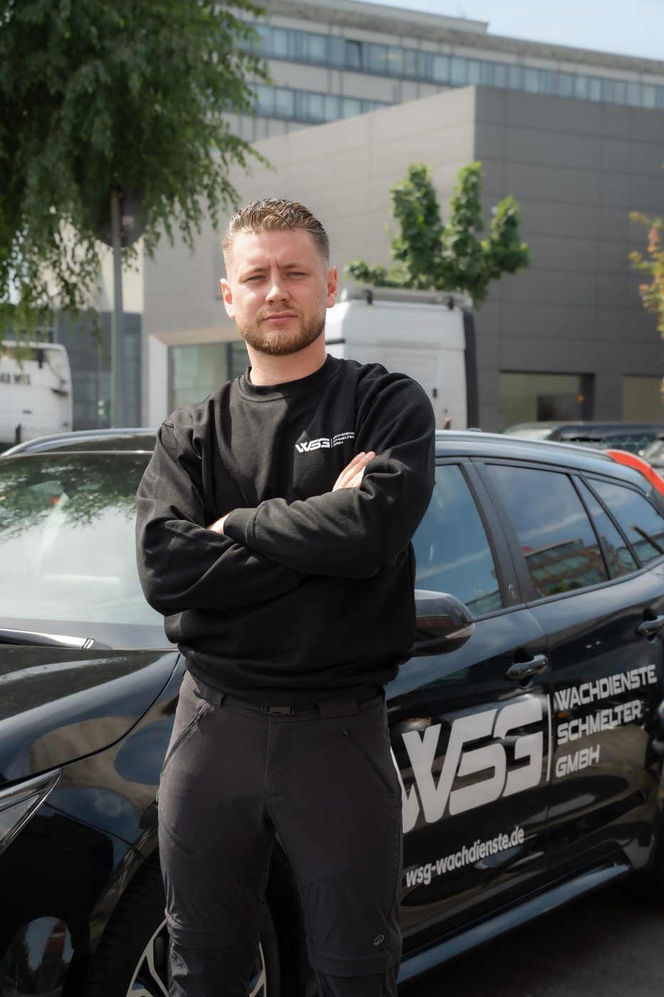 Mitarbeiter der WSG Wachdienste Schmelter GmbH vor einem Dienstfahrzeug